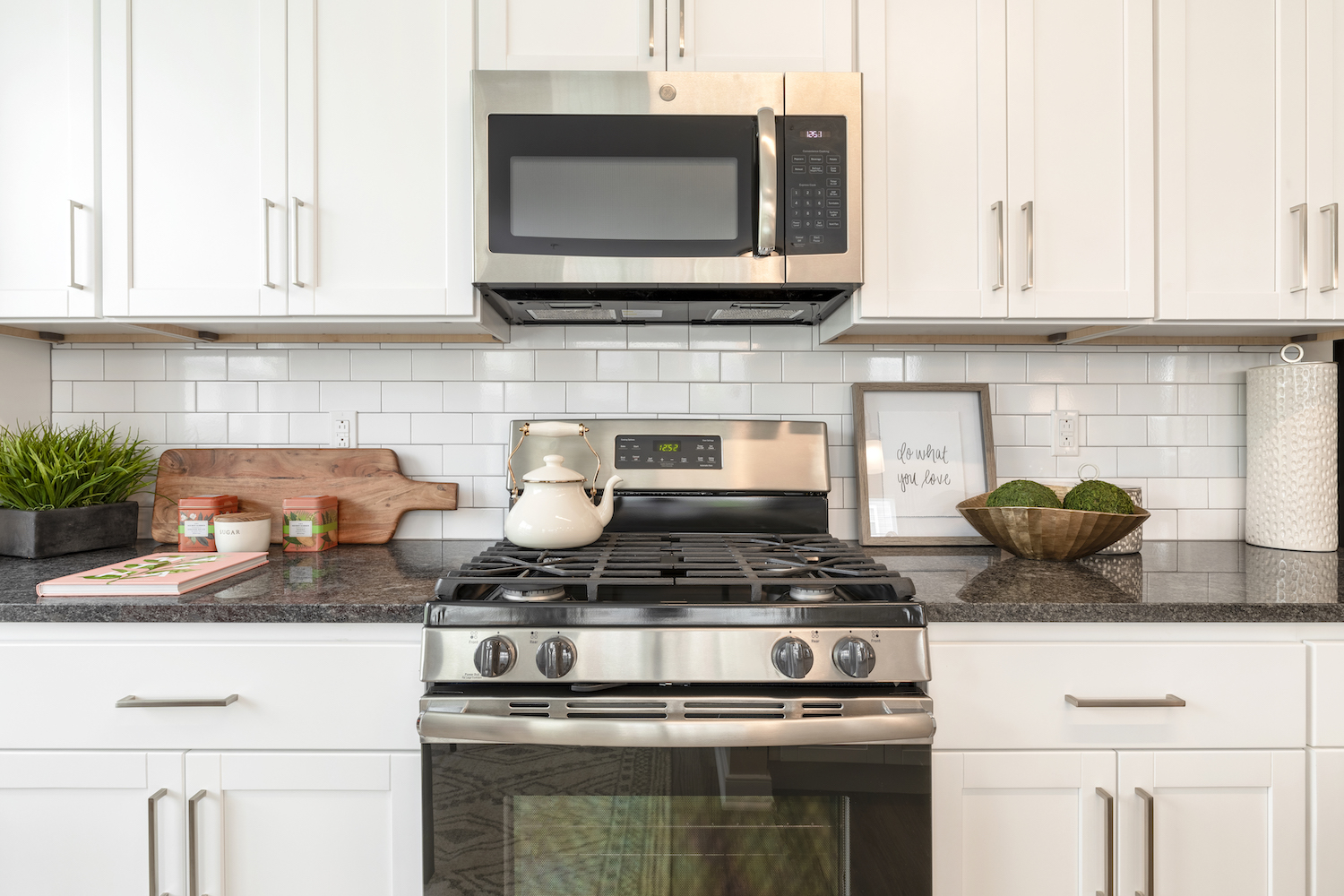 Refinery kitchen with white cabinets and stainless appliances.