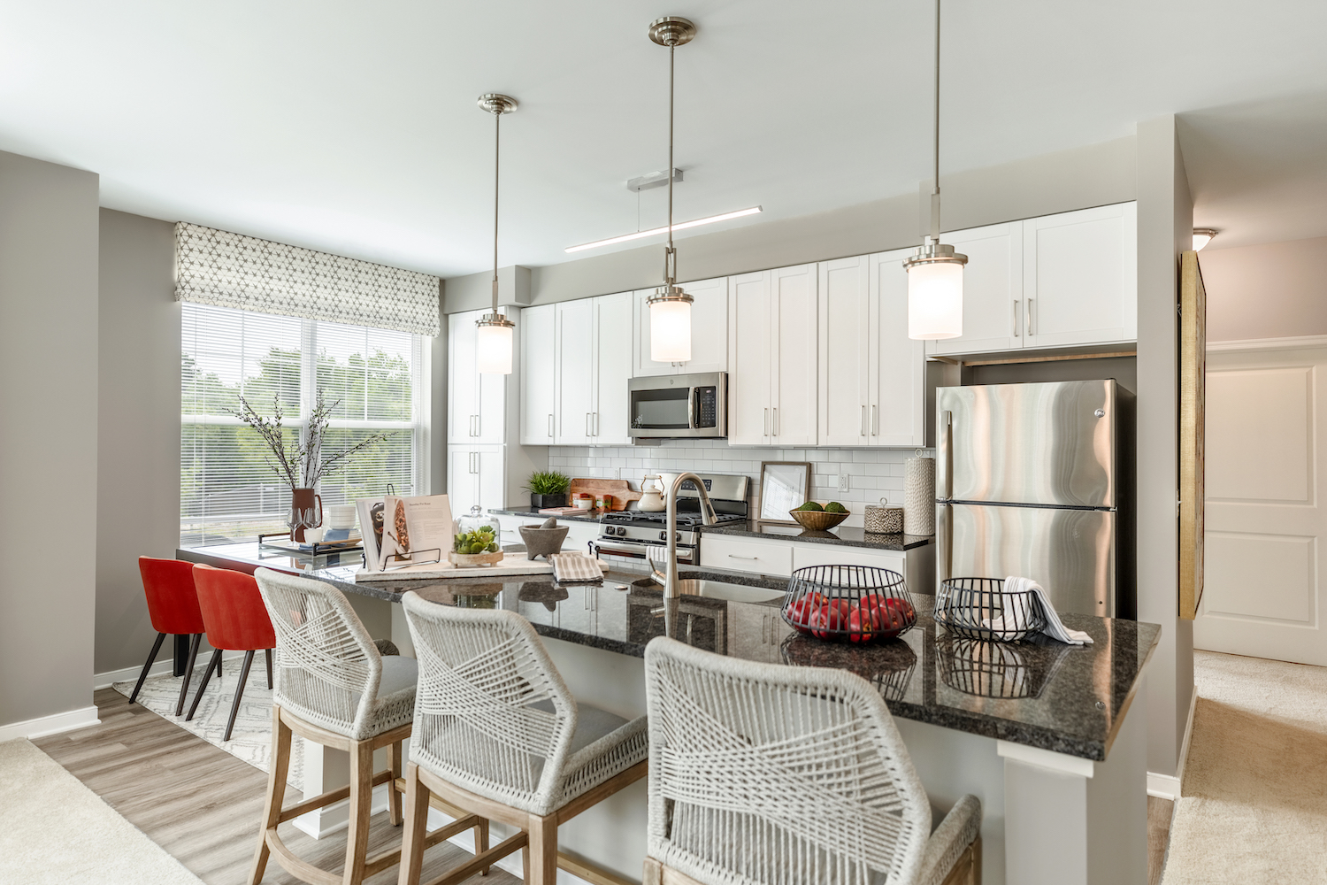 Refinery kitchen with white cabinets and stainless appliances.