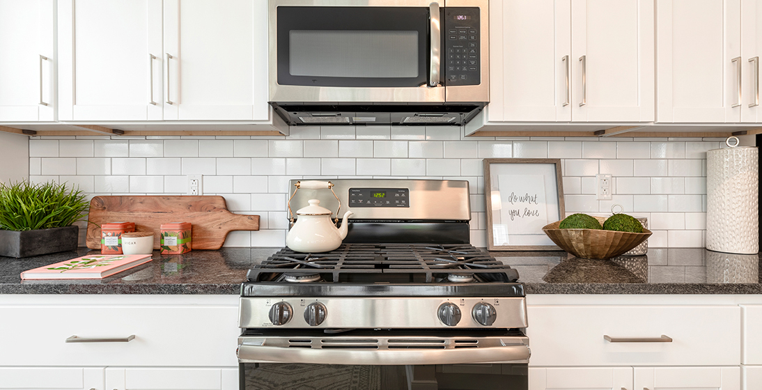 Refinery kitchen with white cabinets and gas cooking